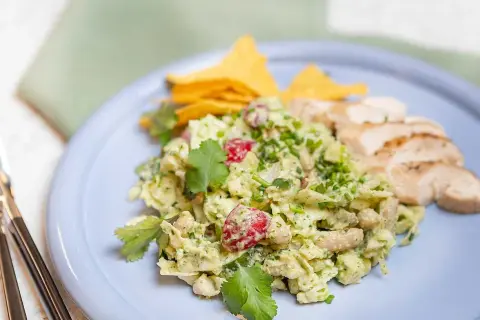 En krämig kycklingsallad med avokado och körsbärstomater, serverad med tortillachips och grillad kyckling. Ett perfekt kycklingsallad recept för en lätt lunch.