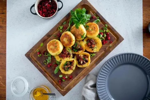 Kroppkakor recept: Gyllene kroppkakor fyllda med fläsk och toppade med färsk persilja, serverade med lingon och senap.