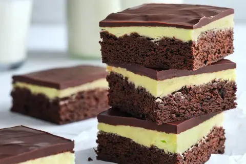 En stapel chokladiga brownies i långpanna med mintgrön fyllning och chokladglasyr. Perfekt för fikat!