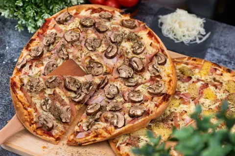 Två läckra pizzor, en med svamp och skinka, den andra med ananas. Perfekt för en mysig kväll, men tänk på libapizza kalorier!