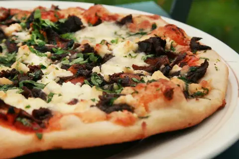En härlig napolitansk pizza på grillen, med mörka svampar och krämig ost.