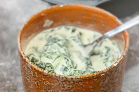 En skål med krämig stuvad spenat, perfekt som tillbehör.