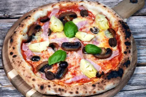 En läcker pizza capricciosa med champinjoner, kronärtskocka, skinka och oliver. Perfekt för ett mysigt kvällsmål, detta recept är en favorit.