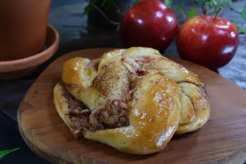 En gyllene kanelbulle med äppelbitar, redo att avnjutas.