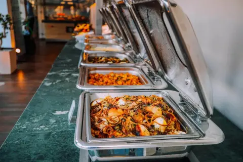 Buffé med olika rätter, perfekt för studentmottagning mat. Varma och inbjudande maträtter i serveringskärl.