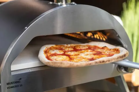 En pizza med tomatsås och ost bakas i en ugn på en pizzasten eller pizzastål.