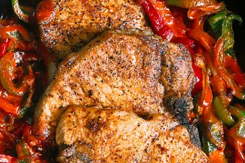 Saftiga kotletter i ugn med paprika och lök. En härlig middag som doftar underbart.