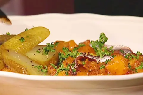 En portion pytt Bellman med stekt potatis, inlagd gurka och en ansjovisfilé.