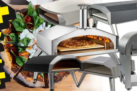 En samling pizzaugnar för grillen, redo för ett fcc bbq pizzaugn test. En pizza med färska ingredienser syns i förgrunden.