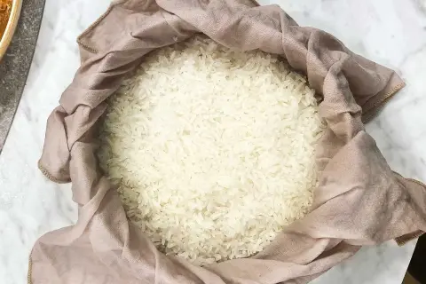 En hög med fluffigt, klibbigt ris inlindat i en ljusrosa tygduk.