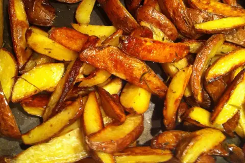 Krispiga klyftpotatis i ugn, gyllene och doftande av örter. Perfekt tillbehör som får det att vattnas i munnen.