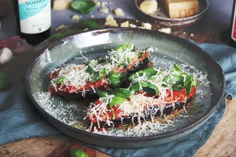 Aubergine i ugn, toppad med tomatsås, basilika och rikligt med parmesanost. En läcker italiensk rätt som doftar underbart.