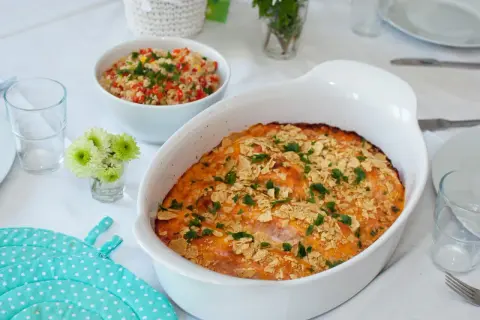 En gratinerad laxrätt med krispigt topping, perfekt för ett fredagsmys recept. Serveras med en fräsch couscoussallad.