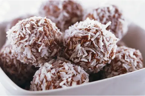 En skål med nyttiga chokladbollar, rullade i kokosflingor. Perfekta för fikat!