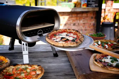 En pizzasten ugn med perfekt temperatur för krispiga pizzor. Flera läckra pizzor ligger redo att serveras.