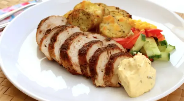 Skivad kycklingfilé, perfekt grillad, serveras med potatis, grönsaker och en klick krämig sås. En härlig måltid!