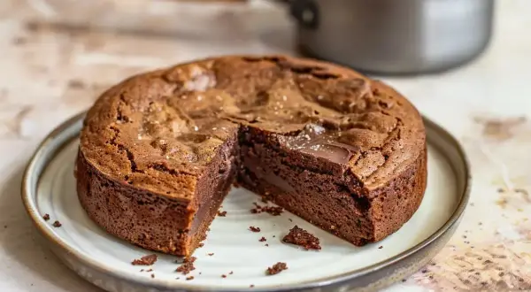 Kladdkaka med saltkristaller, perfekt för ett enkelt kladdkaka recept. En bit är bortskuren och visar den härliga, kladdiga insidan.