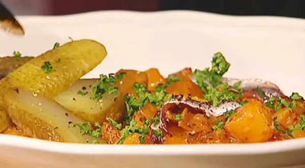 En portion pytt Bellman med stekt potatis, inlagd gurka och en ansjovisfilé.