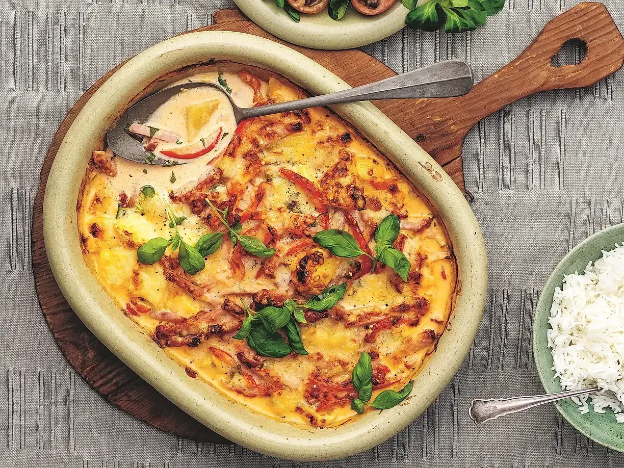 En krämig kasslergratäng med ananas och paprika, toppad med färsk basilika. Ett perfekt kassler recept för middagen.